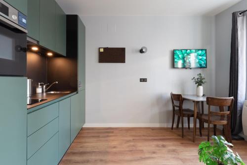 a kitchen with blue cabinets and a table with chairs at Travel Homes - The Parc, next to Champ de Mars in Colmar
