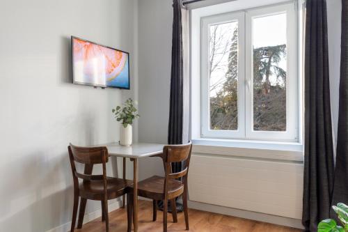 a table and chairs in a room with a window at Travel Homes - The Parc, next to Champ de Mars in Colmar