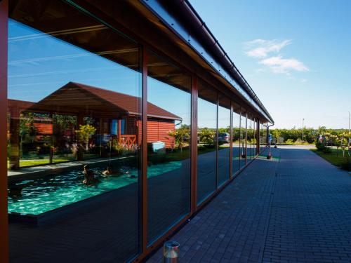 un reflejo de una piscina en las ventanas de un edificio en Ostoja Maltańska, en Jarosławiec