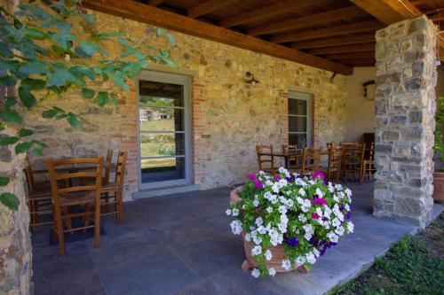 a patio with a bunch of chairs and flowers at Agriturismo I Giunchi in Mochignano