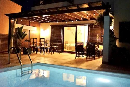 basen z patio, stołem i krzesłami w obiekcie Villa Tabaiba Playa Blanca Lanzarote w mieście Playa Blanca