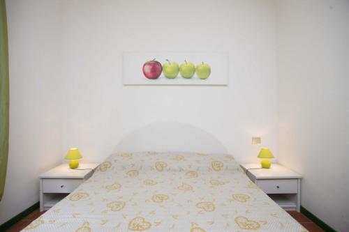 a white bedroom with a bed with two night stands at Sant'Anna Vicolo Aranci 5 in Portoferraio