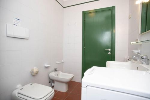 a bathroom with a toilet and a green door at Sant'Anna Vicolo Aranci 5 in Portoferraio