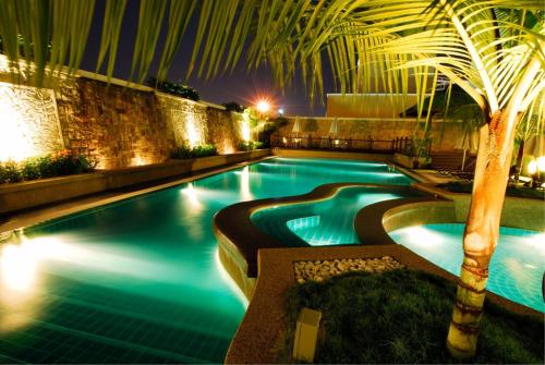 a swimming pool at night with a palm tree at Royale Chulan The Curve in Petaling Jaya