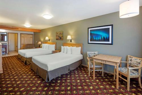 a hotel room with two beds and a table and chairs at Best Western King Salmon Inn in Soldotna