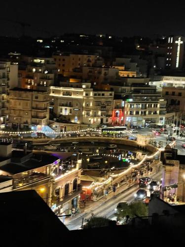 a city at night with cars on a street at Spinola Hotel in St Julian's