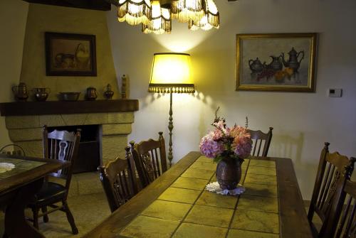 ein Esszimmer mit einem Tisch und einer Vase aus Blumen in der Unterkunft Casa Mari Paz Trasvía in Comillas