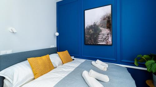 a blue room with a bed with two towels on it at Stone Hill Apartament Sunrise in Szklarska Poręba