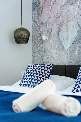 a bed with blue and white sheets and pillows at Stone Hill Apartament Sunrise in Szklarska Poręba