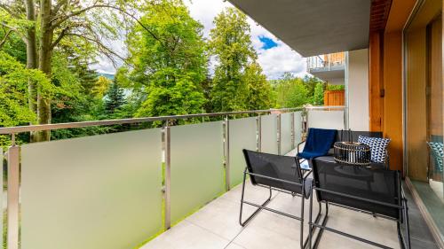 a balcony with two chairs and a table at Stone Hill Apartament Sunrise in Szklarska Poręba