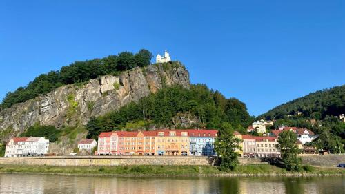 a town on the side of a mountain next to a body of water at Berta's Apartments in Děčín