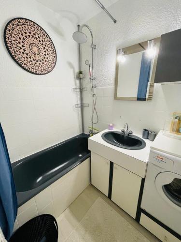 a small bathroom with a sink and a bath tub at F2 près débarcadère, en centre ville, des thermes EVIAN LES BAINS 2 étoiles in Évian-les-Bains
