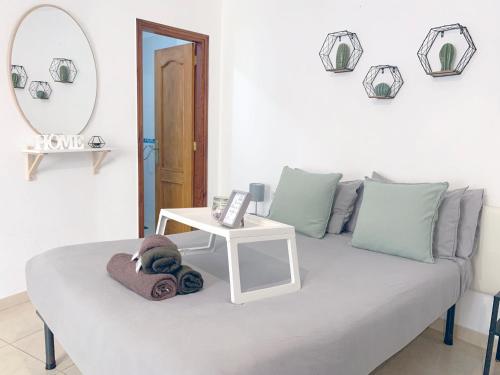 Cette chambre comprend un canapé, une table et un miroir. dans l'établissement The Cozy Studio Los Cristianos, à Los Cristianos