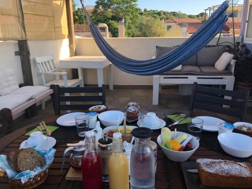 a table with food and a hammock on a patio at Brancadoria B&B in Monteleone Rocca Doria
