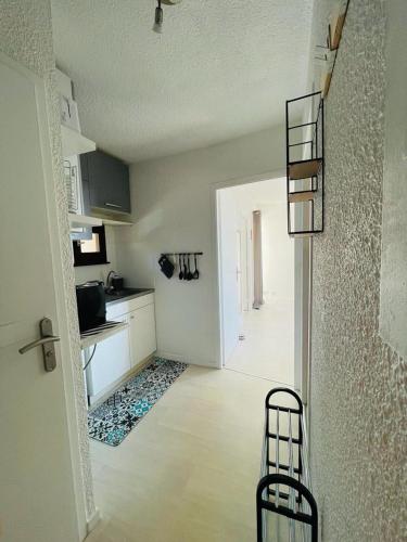 un salon avec une cuisine et un couloir avec un escalier dans l'établissement F2 près débarcadère, en centre ville, des thermes EVIAN LES BAINS 2 étoiles, à Évian-les-Bains