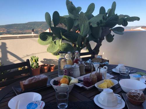 a table topped with plates and bowls of fruit at Brancadoria B&B in Monteleone Rocca Doria