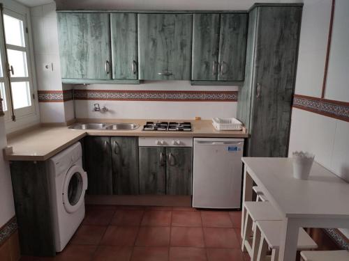 a kitchen with wooden cabinets and a washing machine at Ave Maria 8 in Tarifa