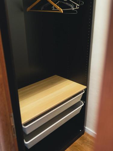 a black refrigerator with wooden shelves and drawers at Penzión u Vinára in Veľký Krtíš