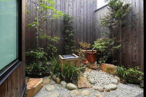 un jardín frente a una valla de madera en TSUBOMI luxury Inn Shimabara Bettei 3, en Kioto