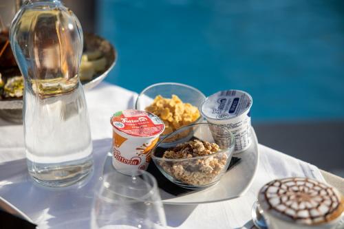 a table with a plate of food and a bottle of water at Giafra Luxury Rooms in Agrigento