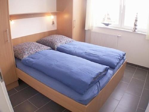 twee bedden in een slaapkamer met blauwe lakens erop bij Meerblick 10 - Großenbrode in Großenbrode