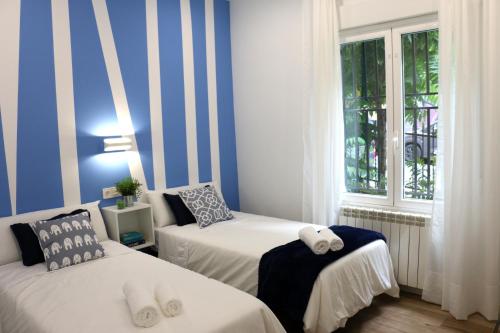two beds in a room with blue and white stripes at Urdintxoenea (Bilbao - Casco Viejo - Nuevo - Parking opc. - WIFI) in Bilbao