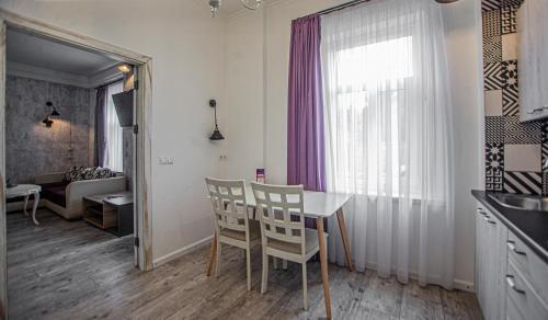 a kitchen with a table and chairs and a living room at Biplan Hotel in Daugavpils