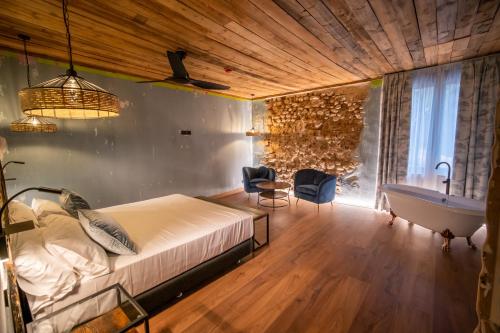 a bedroom with a bed and a tub and a sink at HOTEL SOMNIFABRIK in Valderrobres