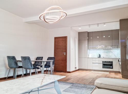 a kitchen and living room with a table and chairs at Apartament VIP CENTRUM in Mrągowo