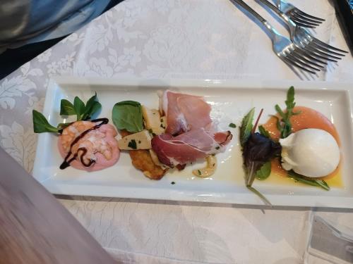 a white plate with food on a table at Hotel Bel Sit in Comano Terme