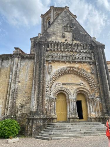 an old building with a yellow door and stairs at Medieval Magic in Vouvant