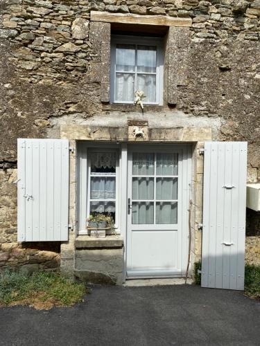a building with a white door and two windows at Medieval Magic in Vouvant