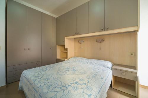 a bedroom with a bed with a blue and white blanket at La Terrazza a Seccheto Sul Mare in Seccheto