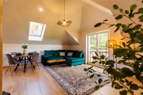 ein Wohnzimmer mit einem grünen Sofa und einem Tisch in der Unterkunft Stylowe apartamenty in Charzykowy
