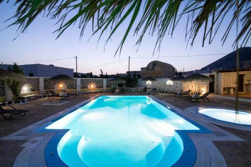a large swimming pool in a resort at night at Mandilaria Studios in Perivolos