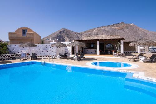 a resort with a large swimming pool and a building at Mandilaria Studios in Perivolos