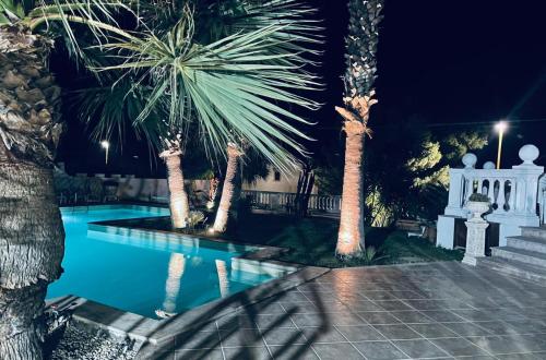 einen Pool mit Palmen und einem weißen Zaun in der Unterkunft Manca Residence in Marina di Palma