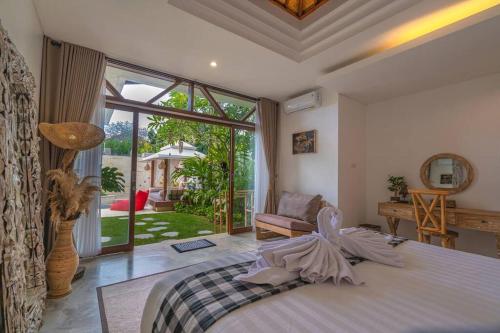 ein Schlafzimmer mit einem Bett und einem großen Fenster in der Unterkunft Miracle villa Canggu in Canggu