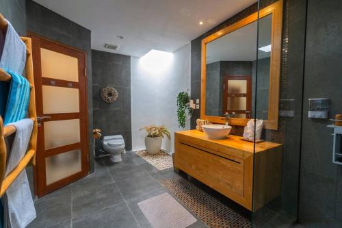 ein Badezimmer mit Waschbecken, Spiegel und Toilette in der Unterkunft Miracle villa Canggu in Canggu