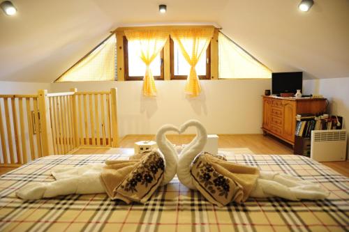 una camera da letto con 2 asciugamani cigni su un letto di Vila Carobni Kutak a Rudno