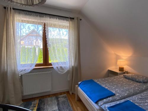 a bedroom with a bed and a window at Dom z widokiem in Krynica Zdrój