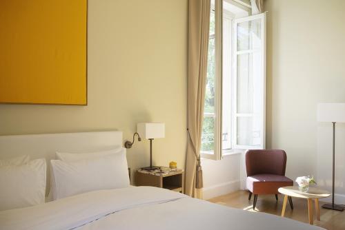 a bedroom with a bed and a chair and a window at Château de Montcaud in Sabran