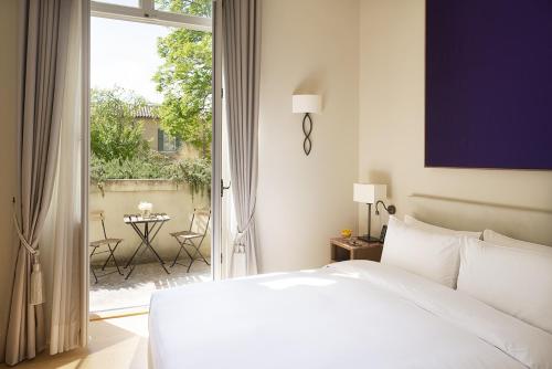 une chambre avec un lit et un balcon avec une table dans l'établissement Château de Montcaud, à Sabran