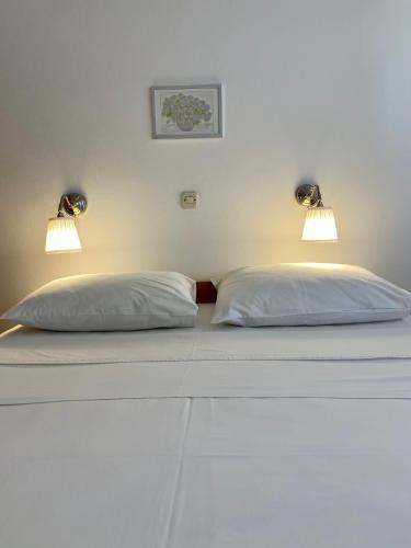a bed with two pillows and two lights on it at Villa Adria in Vodice