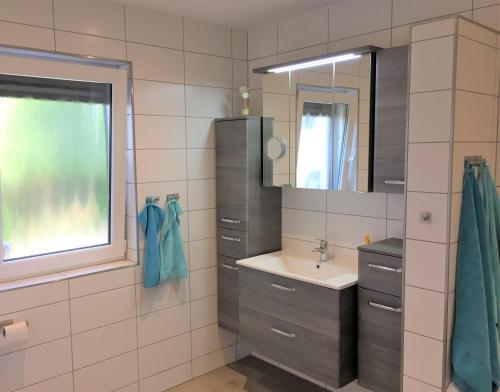 a bathroom with a sink and a mirror at Ferienwohnung Marie in Michelau