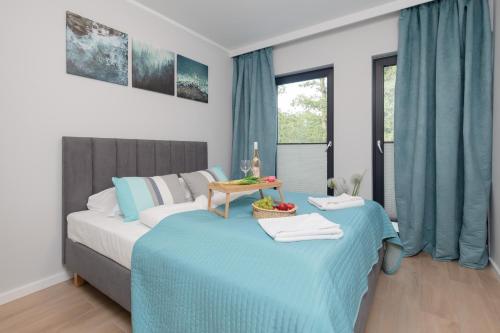 - une chambre avec 2 lits avec des draps bleus et une table dans l'établissement Little Laguna Apartments SPA & Gym by Noclegi Renters, à Międzywodzie