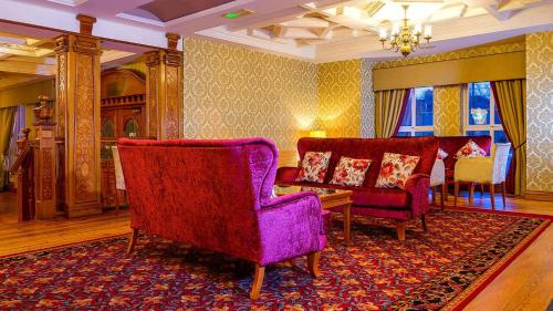 a living room with two chairs and a purple couch at Lady Gregory Hotel, Leisure Club & Beauty Rooms in Gort