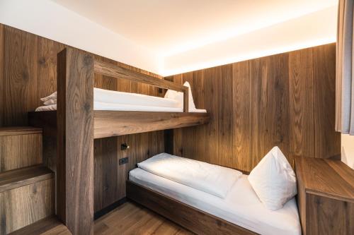 a small room with two bunk beds on a boat at Boutique Hotel Planlim in Ortisei