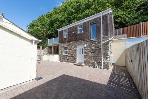 a brick house with a white door and a driveway at Kerensa in Portreath
