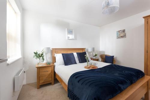 a bedroom with a bed with blue and white sheets at Kerensa in Portreath